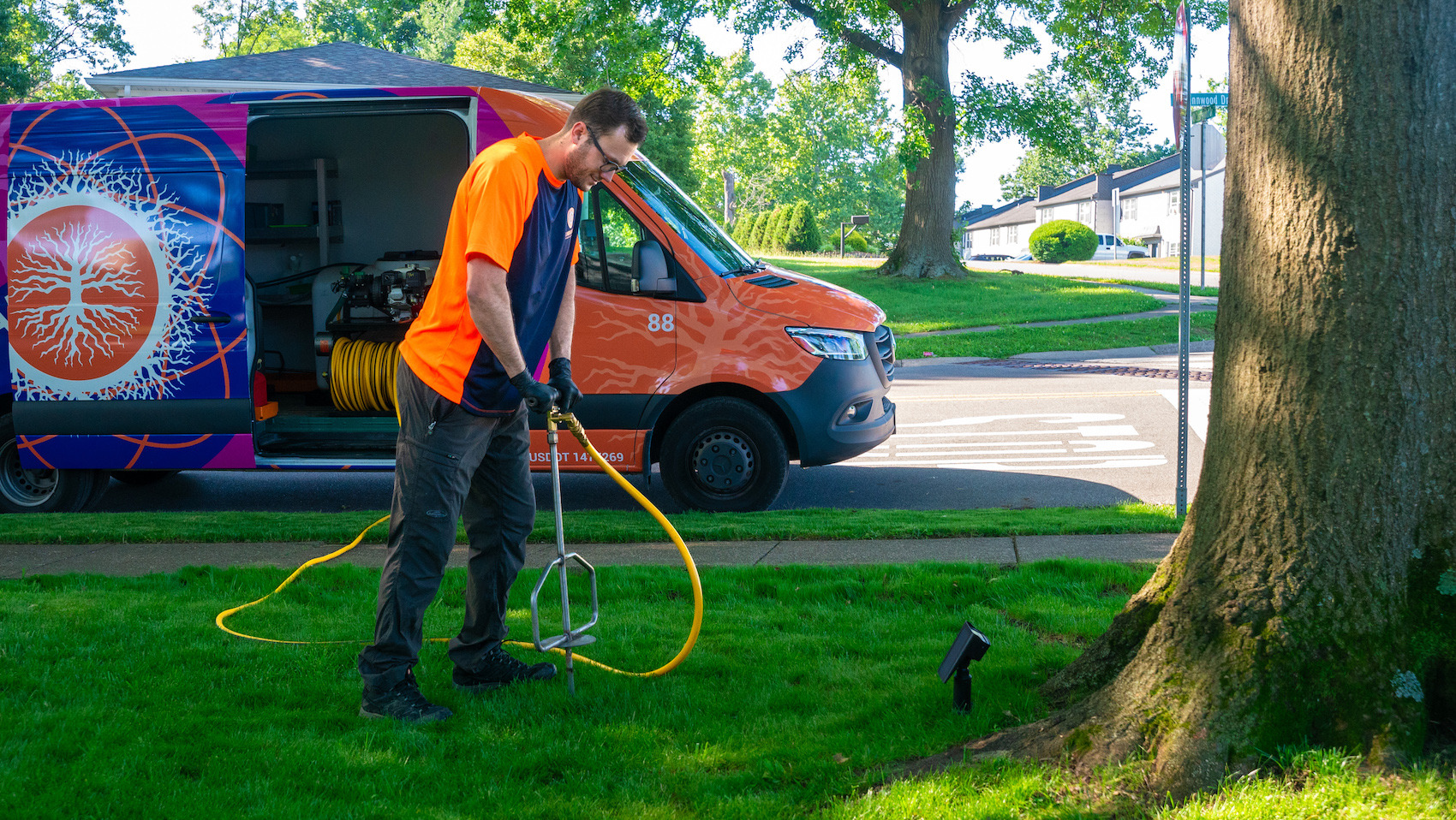 Plant health care technician fertilizing tree