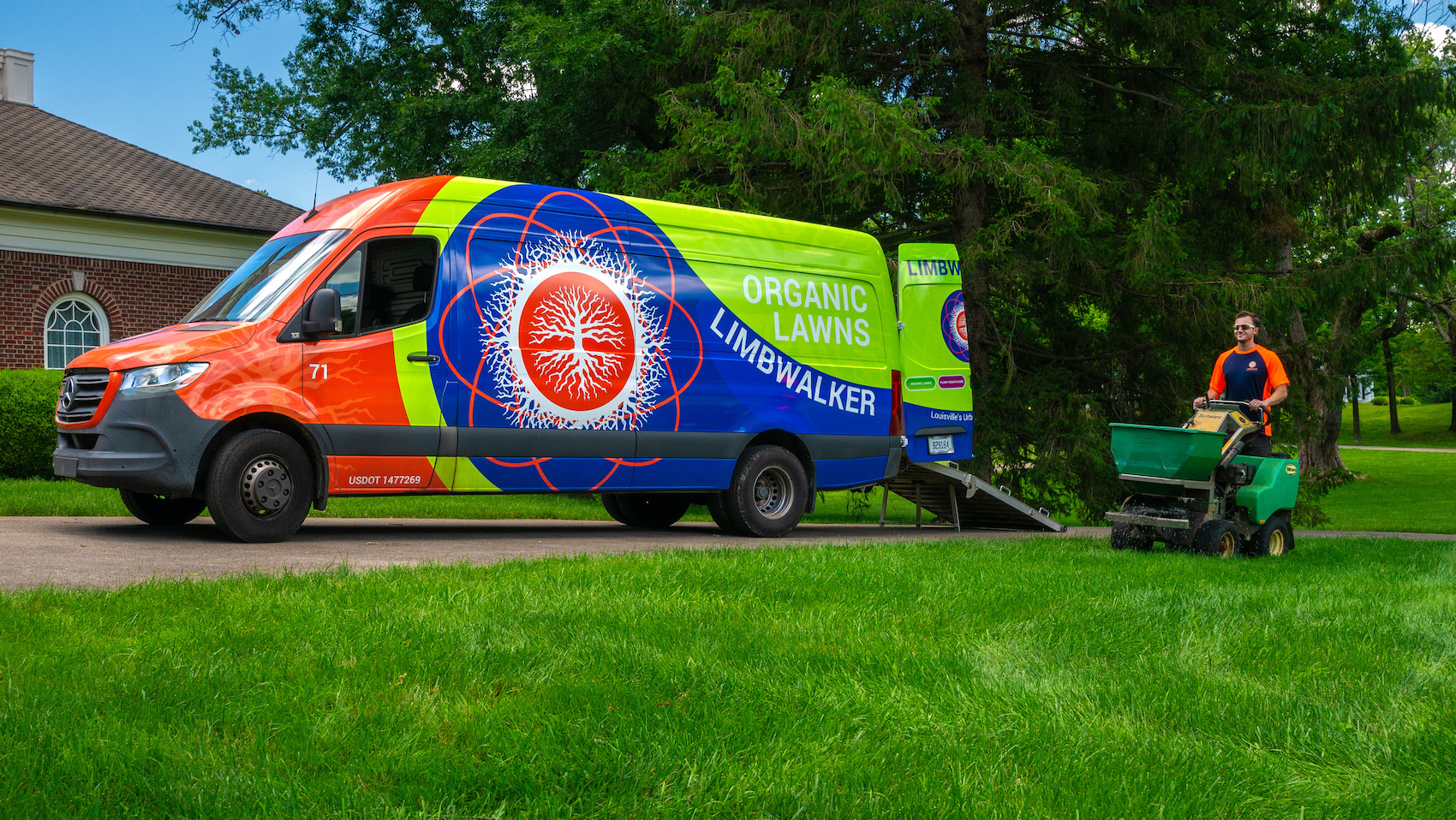 lawn care technician near truck working on lawn 