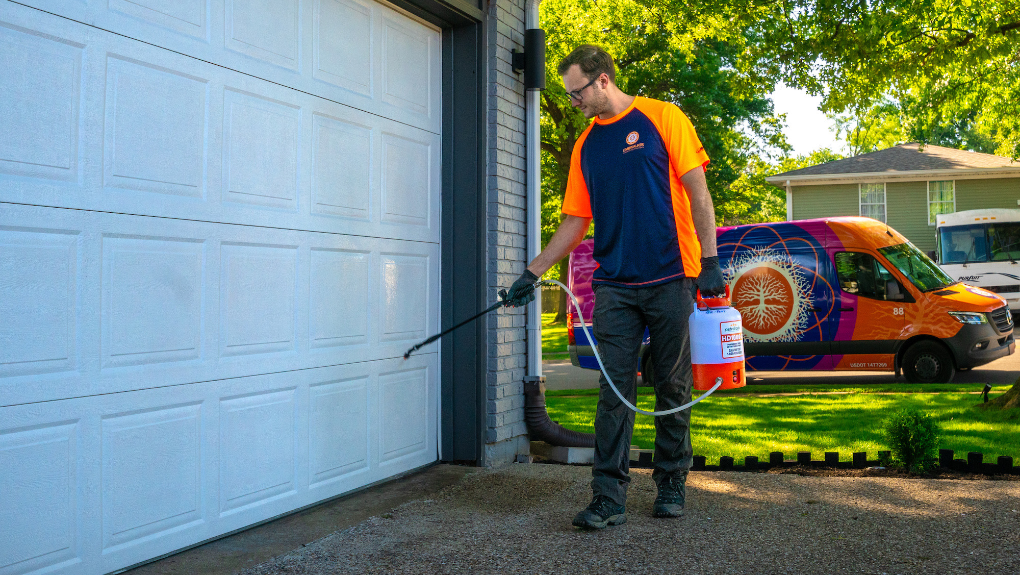 perimeter pest control technician liquid spraying outside of house 5