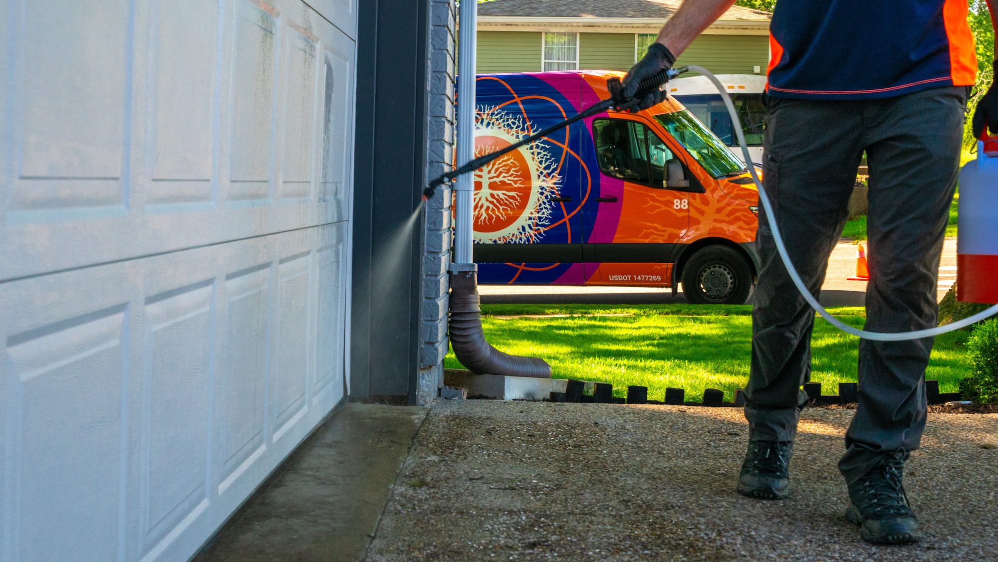 perimeter pest control technician liquid spraying outside of house 7