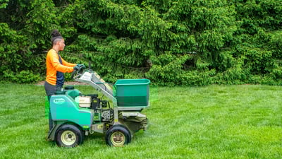 lawn care crew on machine on grass in yard