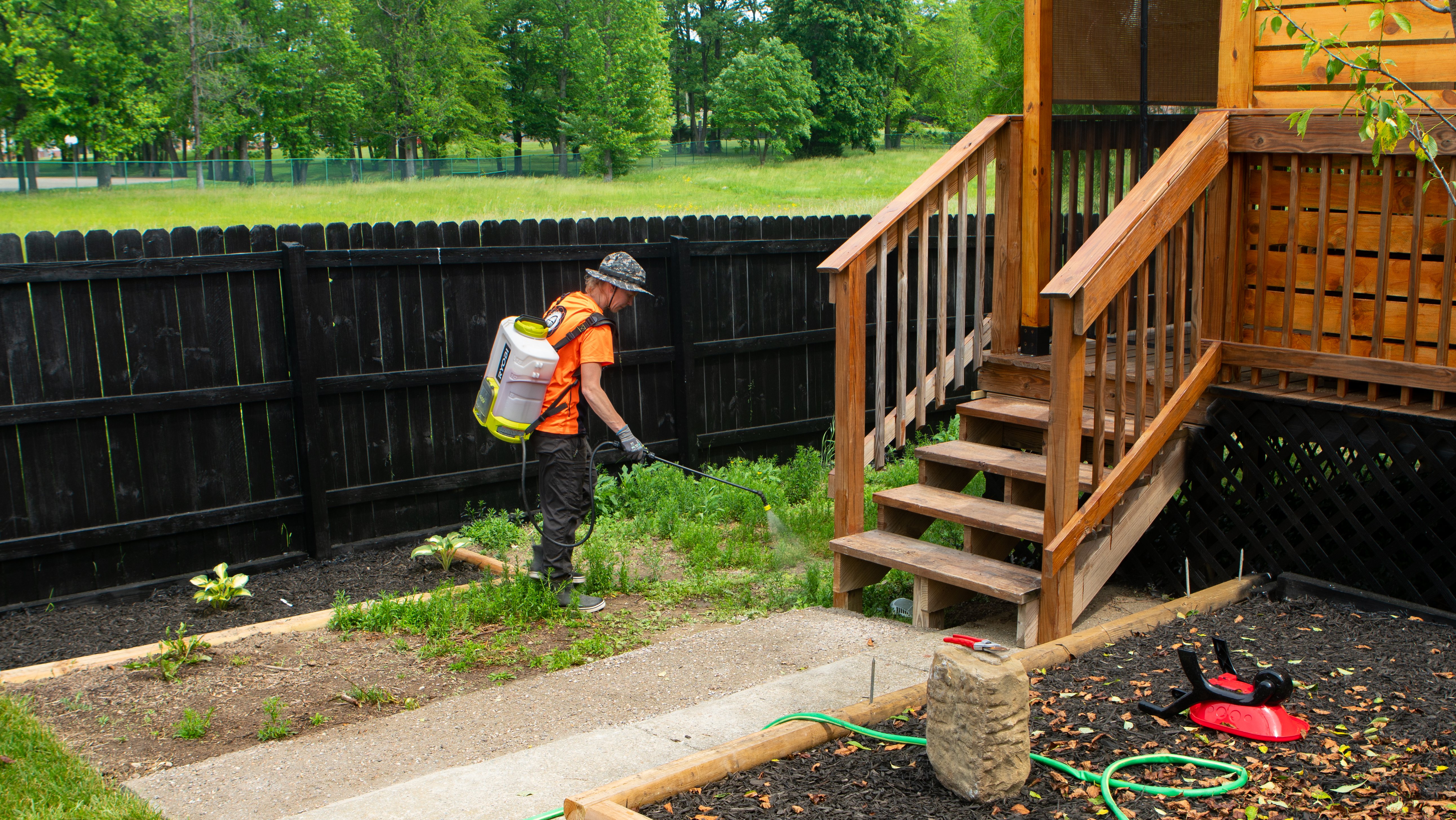 crew killing weeds back yard landscape bed